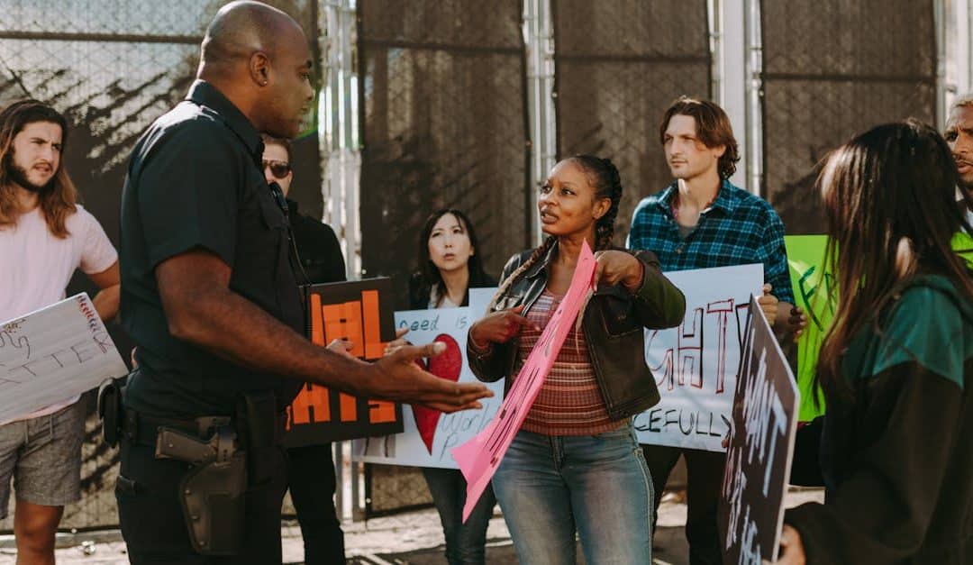 a-diverse-group-of-people-engaged-in-a-peaceful-protest-outdoors-discussing-with-a-police-officer-1